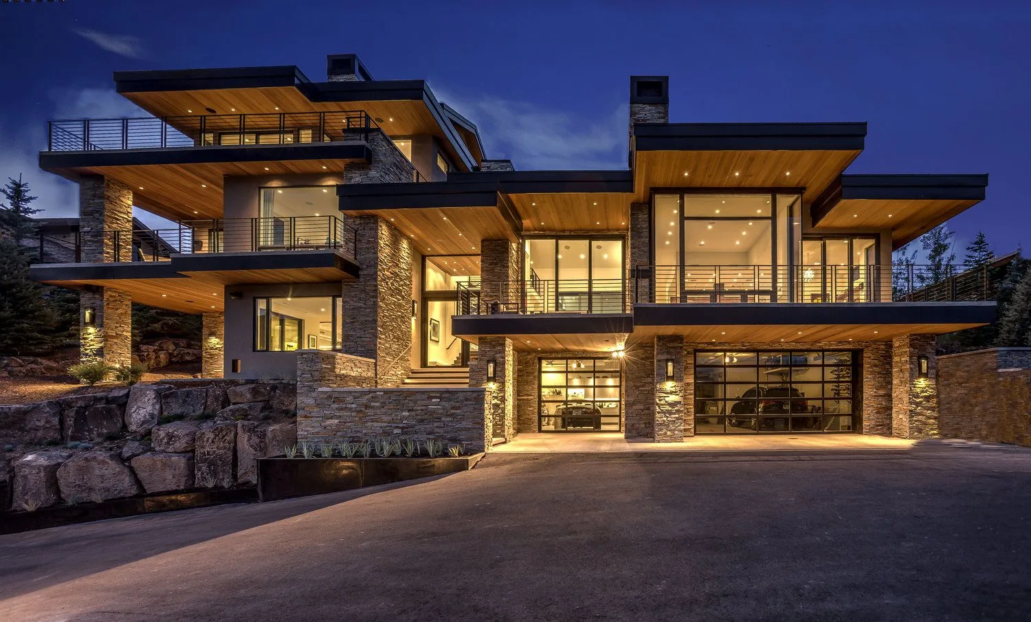A Large House With Lots Of Windows And Lights On It S Front Entrance At Night
