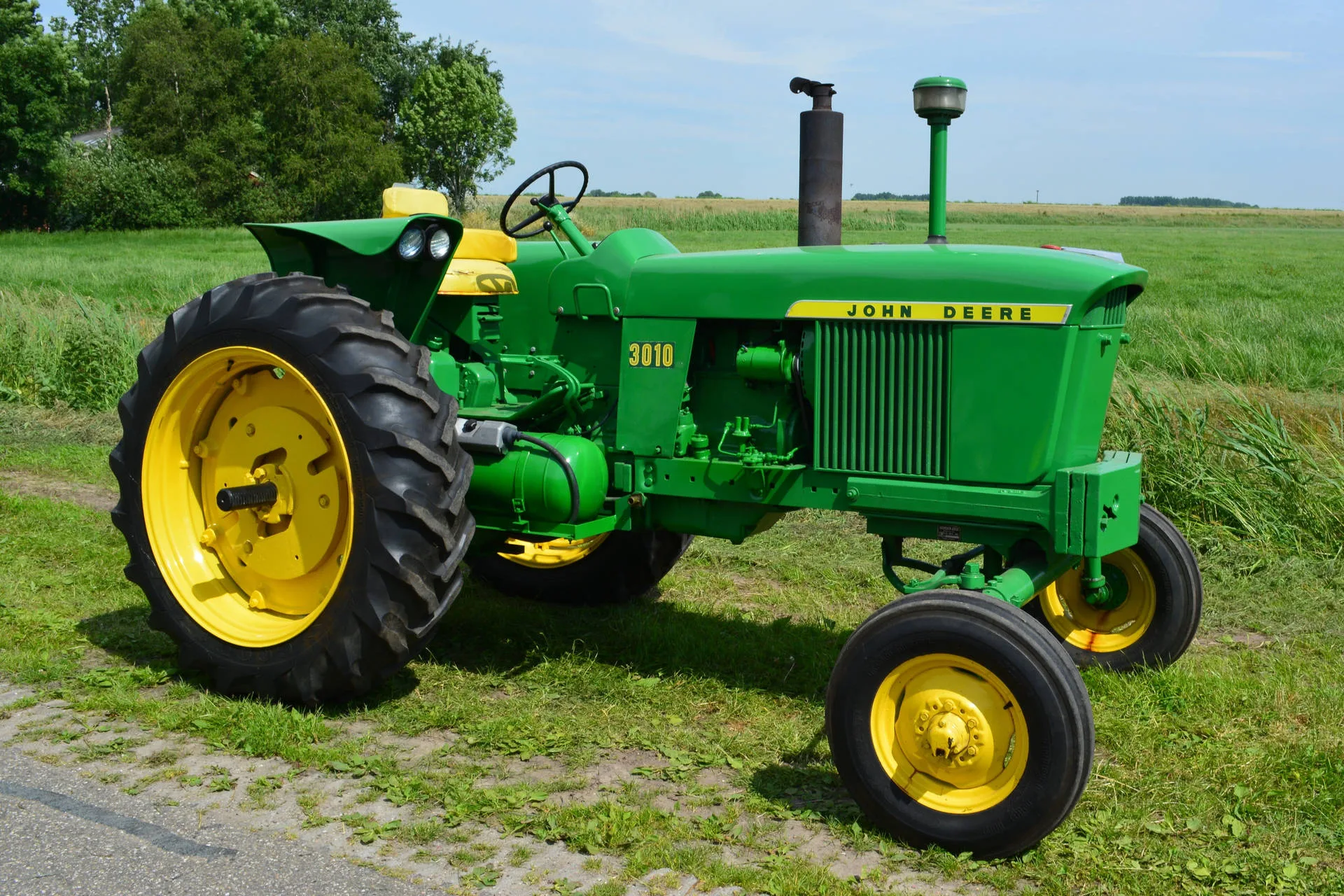 Download Compact Yet Powerful John Deere Tractor In Action Wallpaper