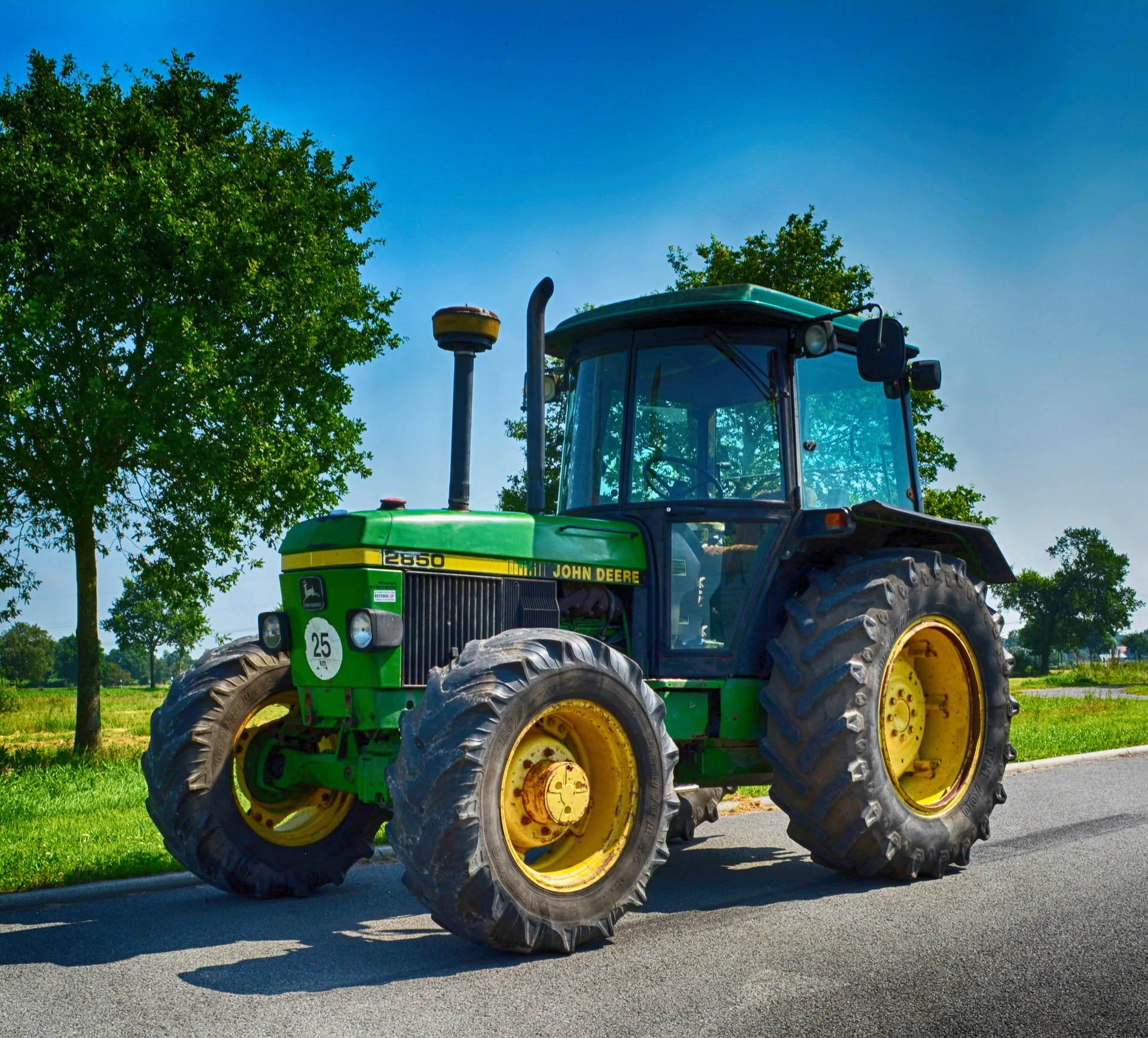 Download Small John Deere Tractor On Road Wallpaper