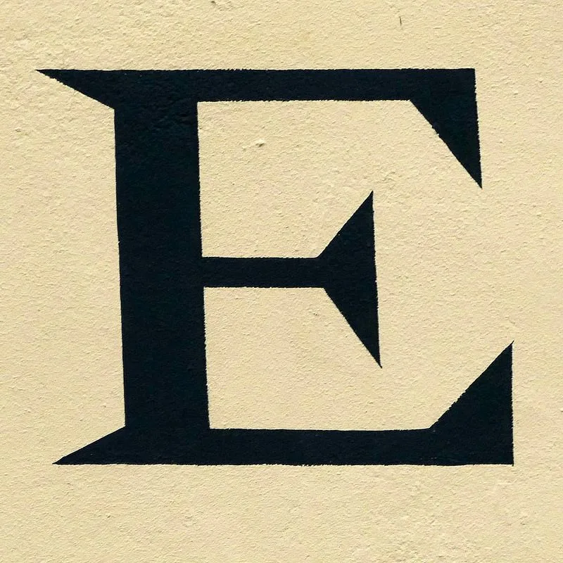 Letter E In Black Ink On White Wall